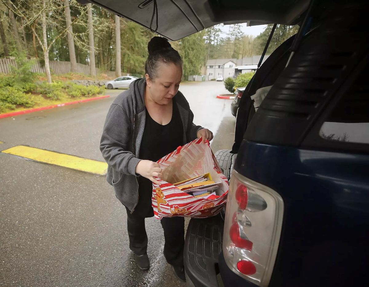 Tatiana Leone removes a bag of paperwork and forms from her vehicle
