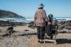 Two elderly women at the coast together watching the waves