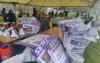 Union members prepare for a strike in the rain beneath a tent. Boxes filled with signs are in the foreground.