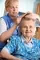 worker combing senior woman's hair