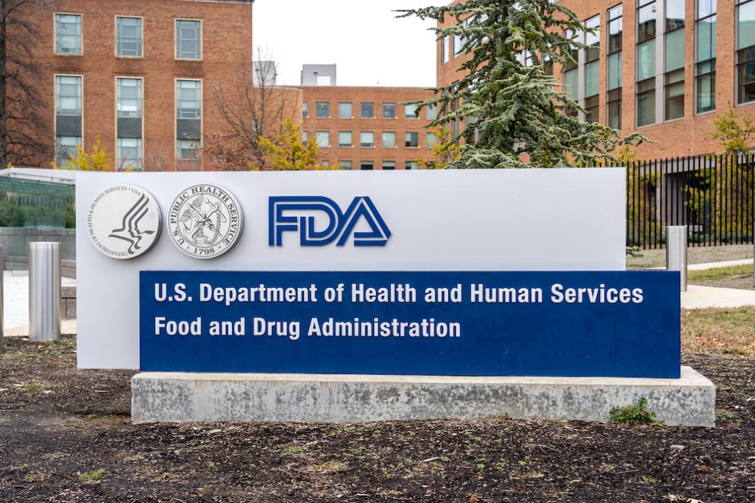 a sign outside a red brick building reads FDA for Food and Drug Administration