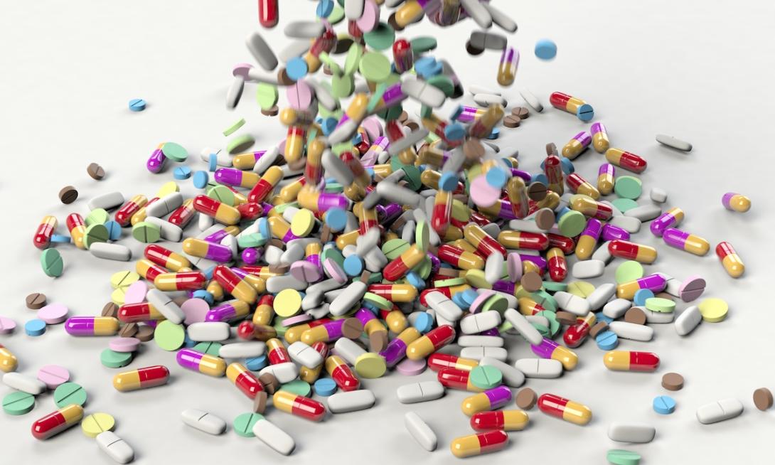 Hundreds of colorful pills falling onto a surface