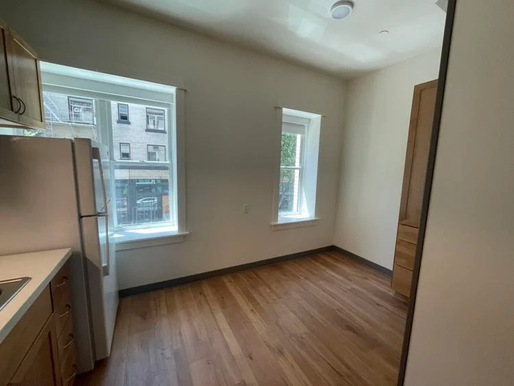 empty apartment kitchen with windows and hardwood floors