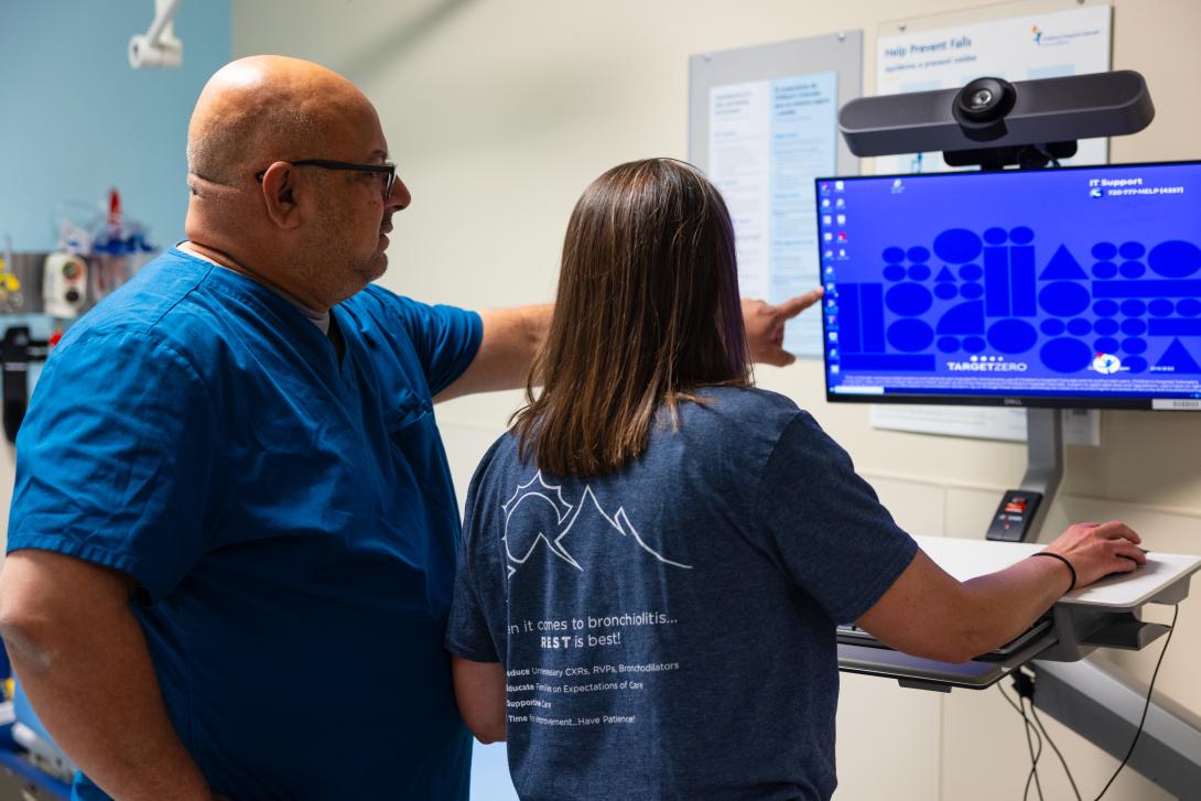 Two doctors look at computer screen