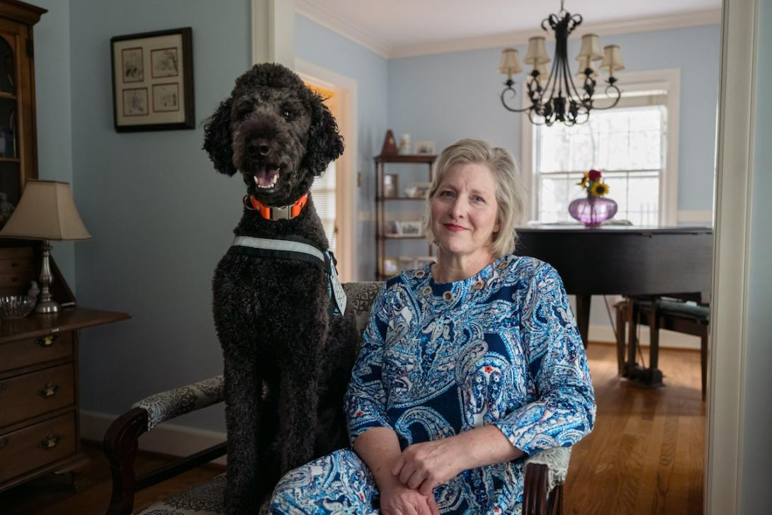 Sally Nix KFF woman sits in living room with dog