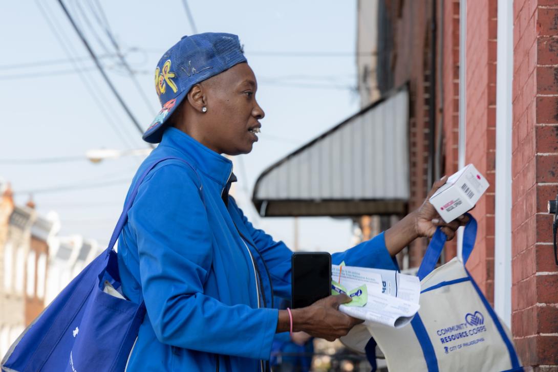 door-knocking man holding leaflet stands at doorstep