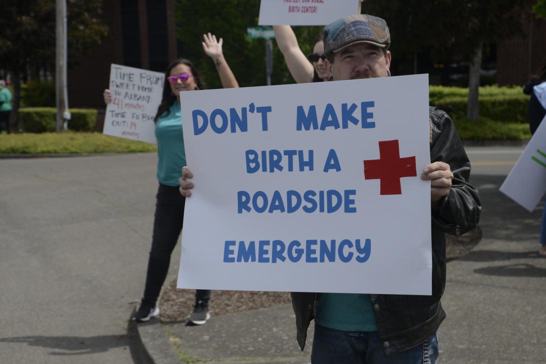 Man holds sign at Samaritan protest