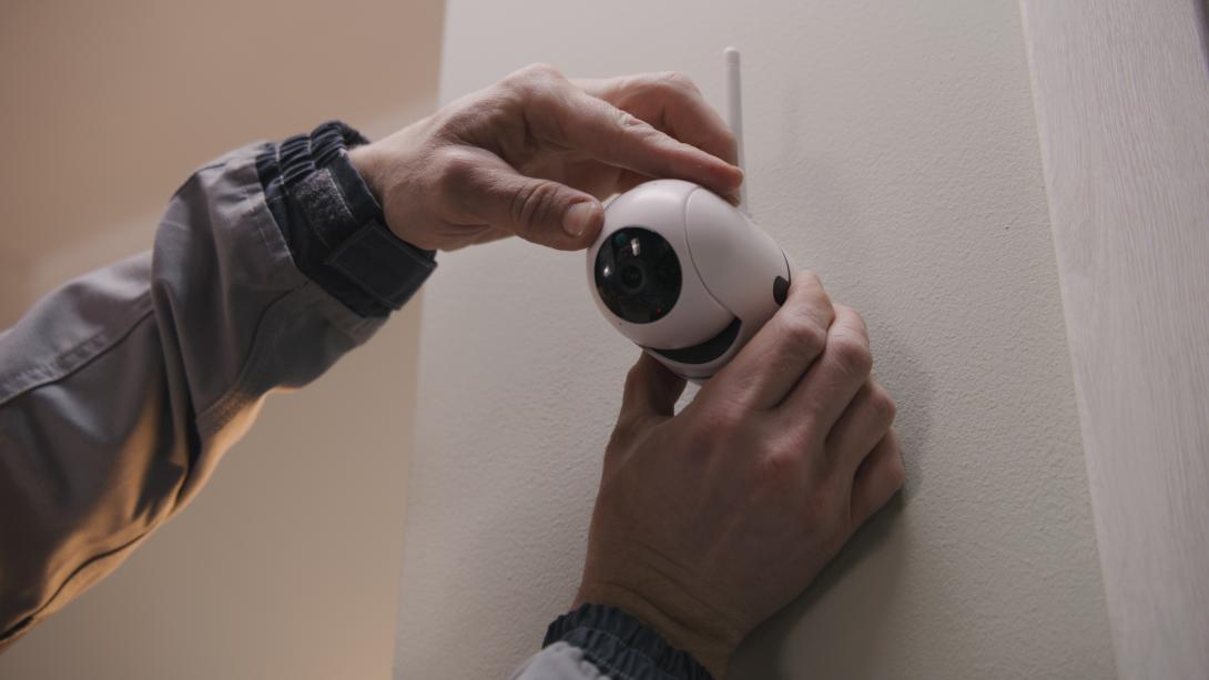 Person is shown installing camera on wall Person installs camera on wall