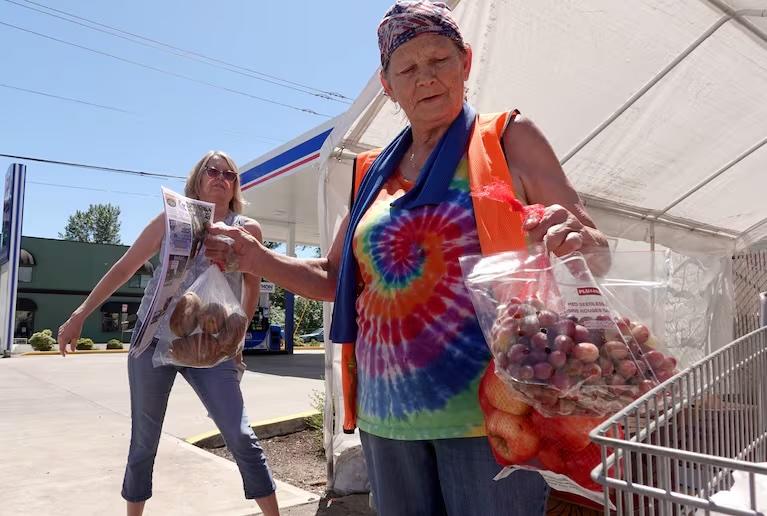A volunteer passes out food boxes in Sheridan, Ore. A volunteer passes out food boxes in Sheridan, Ore.