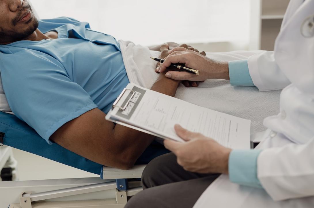 A doctor holds a patient's hand