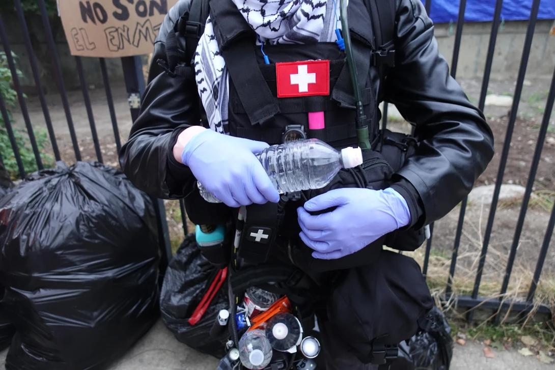 A volunteer street medic who goes by the name Rat is shown outside the ICE protests Oct. 18, 2025