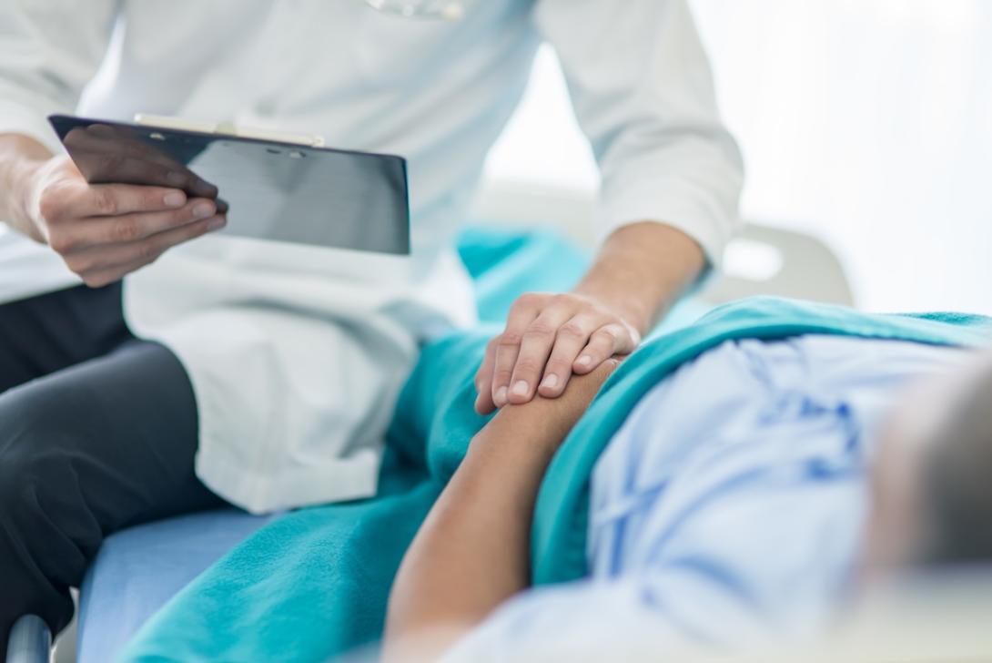 Doctor and patient hold hands