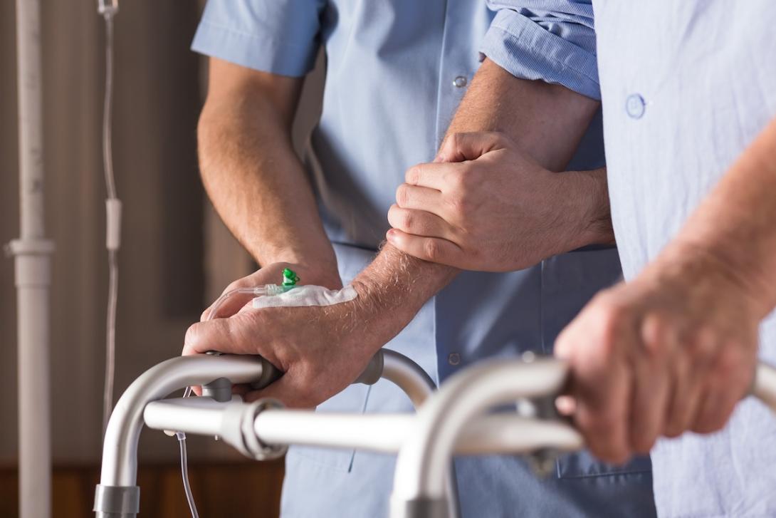 Nurse helping patient with walker