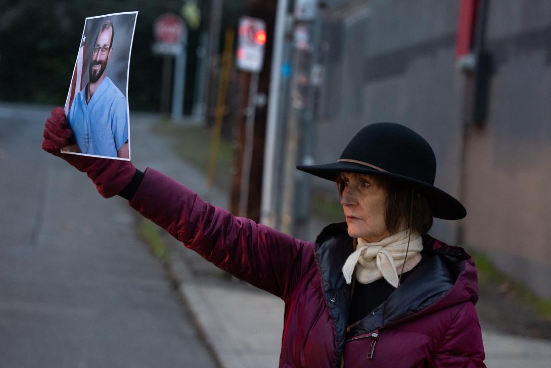 Karen James holds a picture of Alex Pretti during a vigil in Portland on Tuesday.