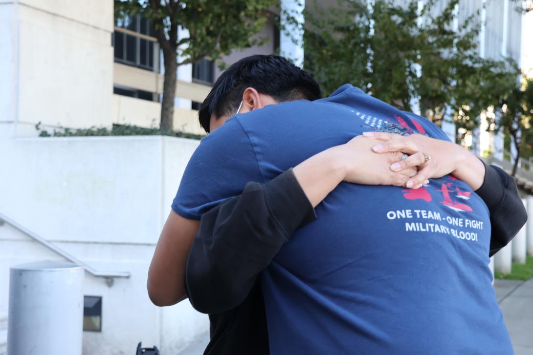 Julio Peña Jr. hugs his stepmother, Lydia Romero, outside an immigration detention facility in downtown Los Angeles as they try to get information about his father, Julio Cesar Peña.