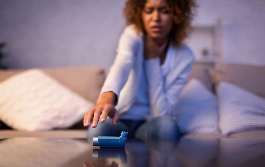 Black woman reaching for inhaler