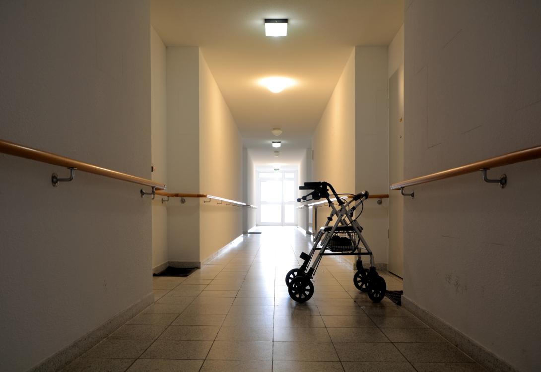 An abandoned walker in a nursing home corridor.