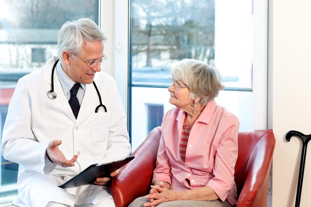 Mature male doctor with mature female patient.