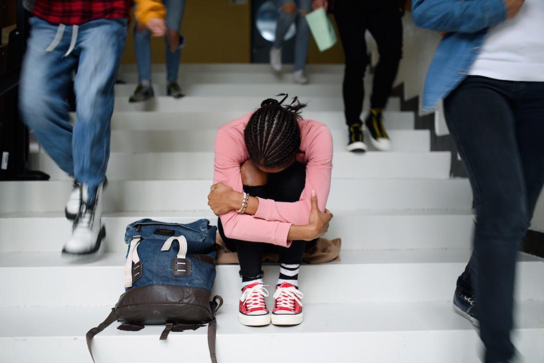Youth on stairs doubled over