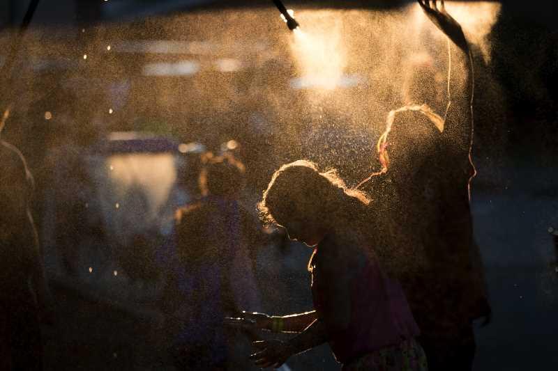 The silhouette of two children under a mister in the evening.