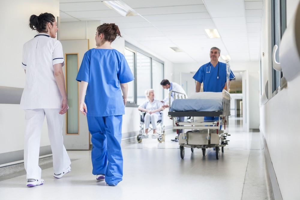 people in surgical scrubs in hospital hallway